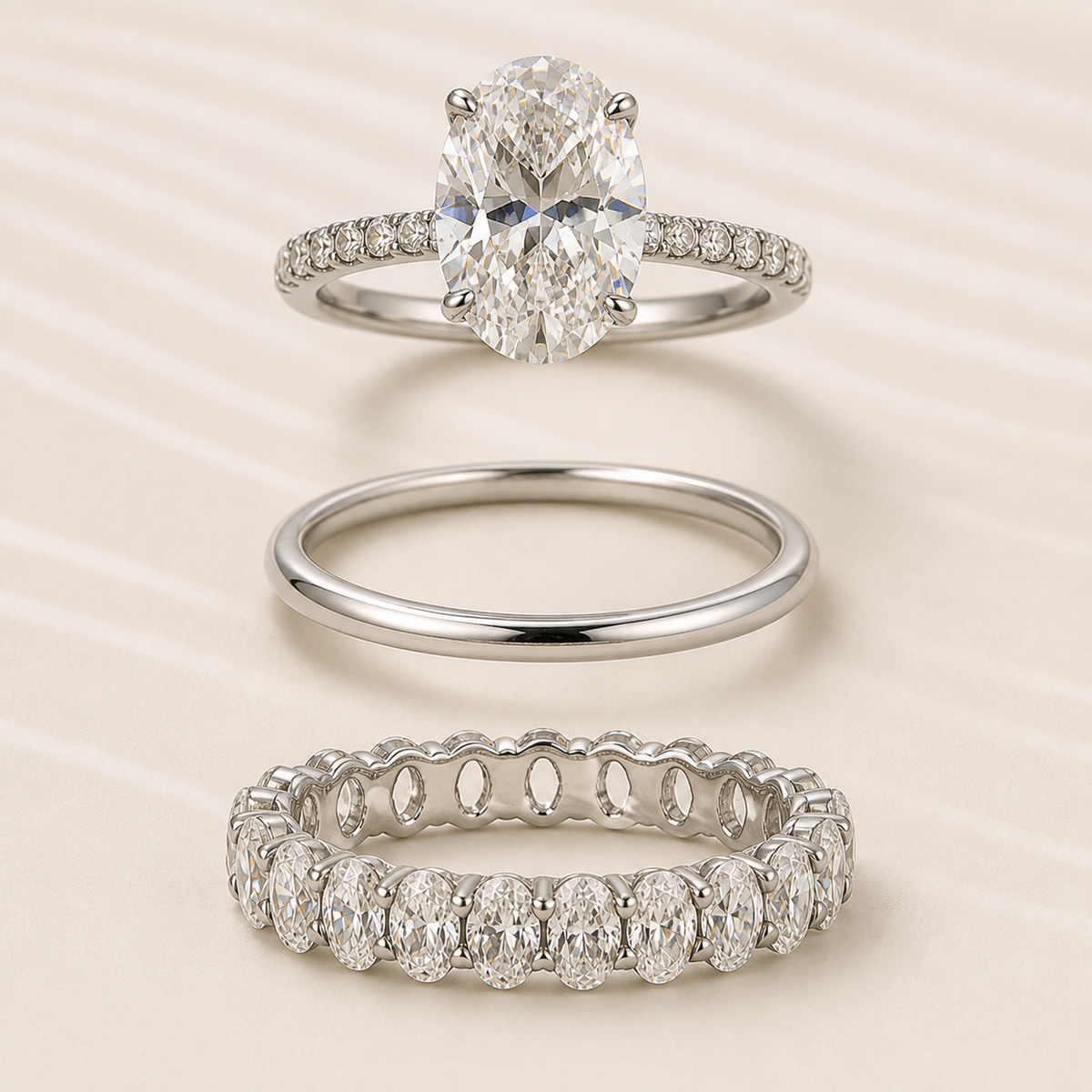 Elara three-piece ring set shown separately: oval engagement ring, polished band, and oval eternity band