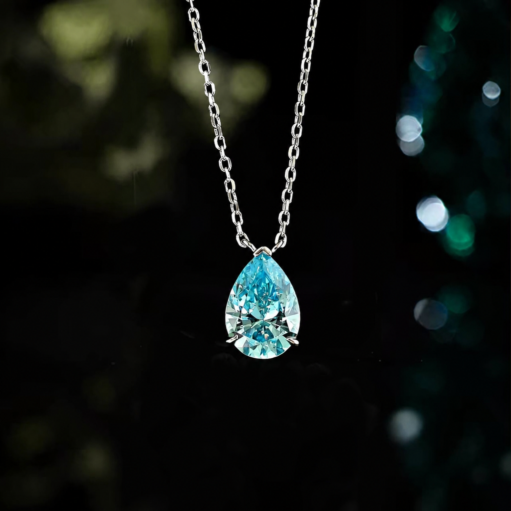 LAVEELLE Azure blue pear-cut pendant necklace on a dark bokeh background
